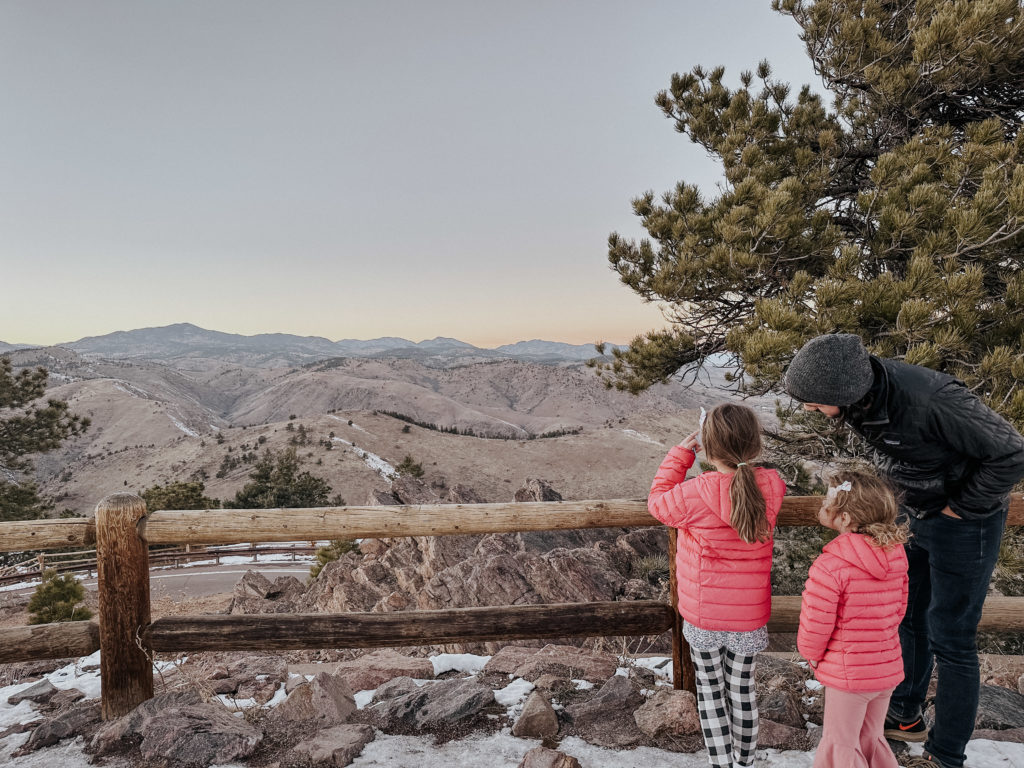 A family looking out over an overview of mountains in Colorado.