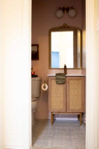 DIY Remodel Pink Bathroom with Blue Floral Patterned Tile Floor and Wood and Cane Vanity