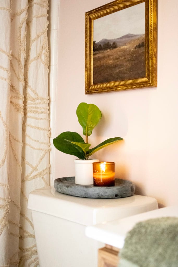Pink walls with gold decor and hardware in our recently updated small bathroom.