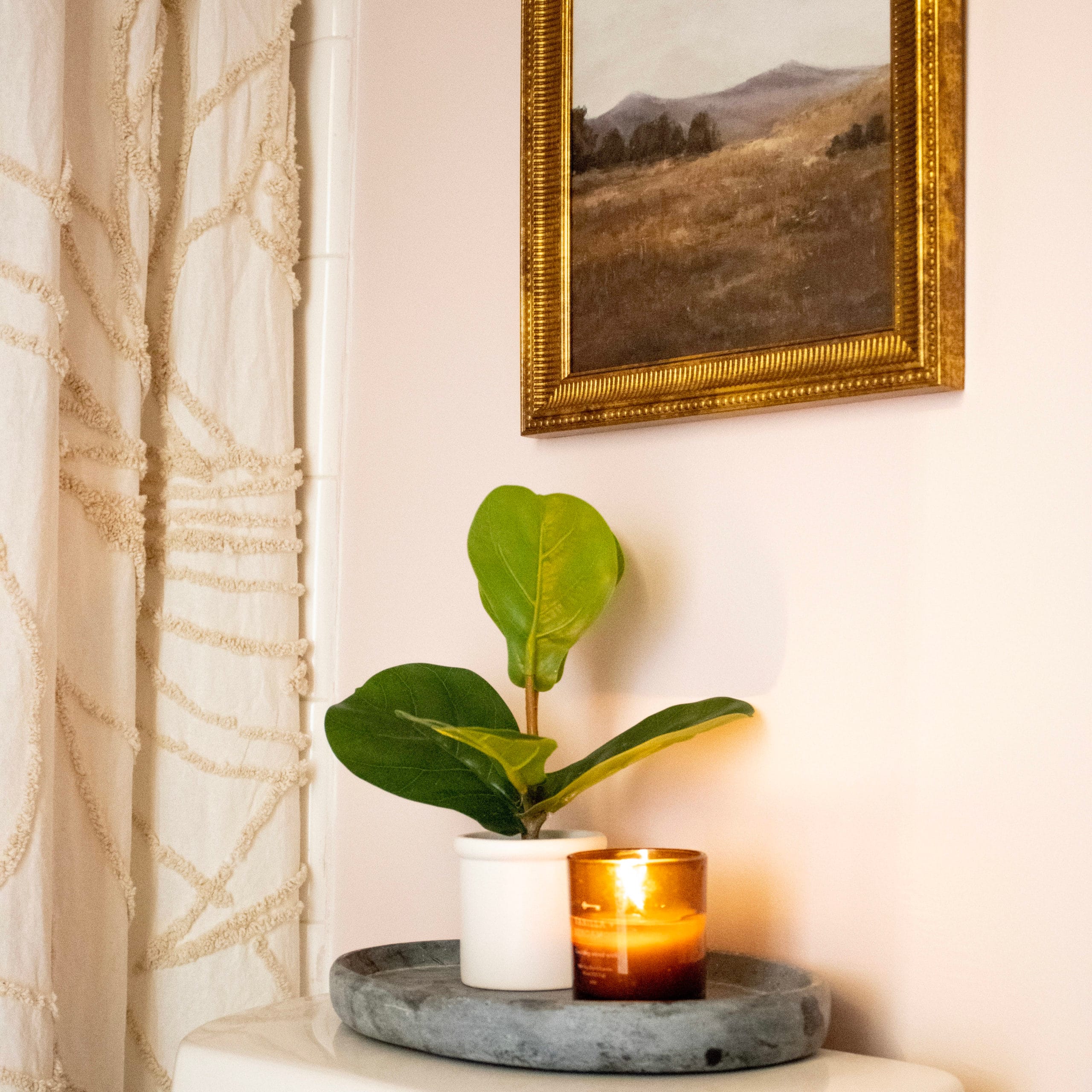 Pink walls with gold decor and hardware in our recently updated small bathroom.