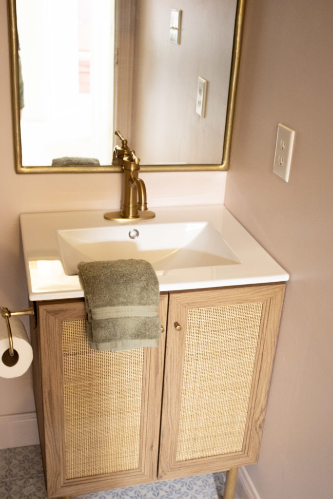 Pink Bathroom Wood and Cane Vanity with Gold Faucet in our DIY hall bathroom remodel
