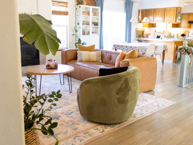 living room with leather couch, green barrel chair and high ceiling