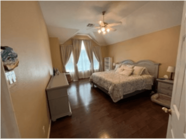 before picture of bedroom with yellow walls, fancy curtains, and shiny wood floors