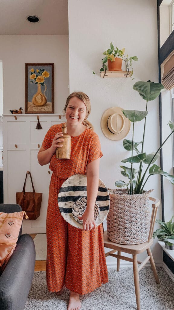 Woman holding wall decor in a white living room
